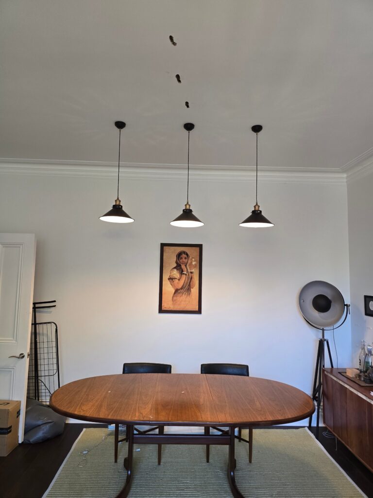Three pendant lights fitted over a dining table